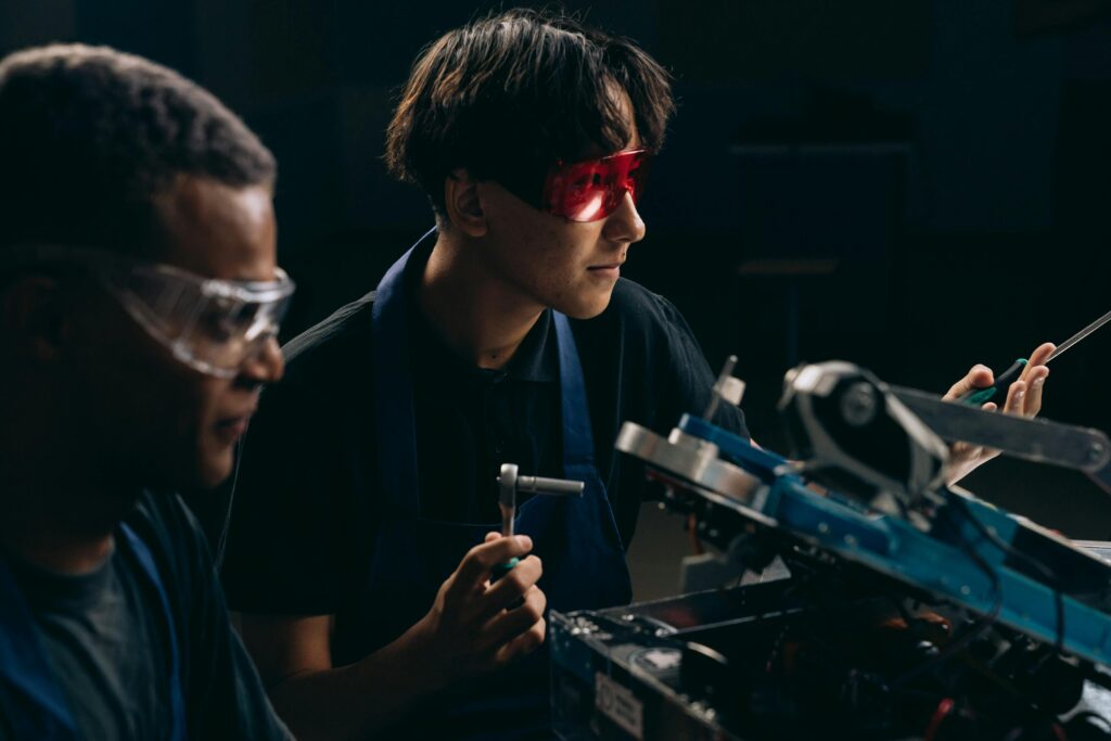 pexels photo 9242207 9242207 Two engineers wearing safety glasses operate machinery indoors, focused on mechanical tasks.